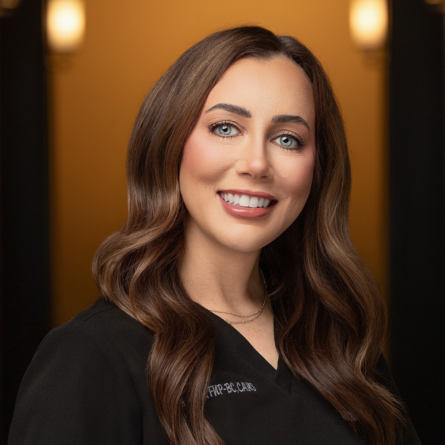 Smiling woman in professional attire, warm background.