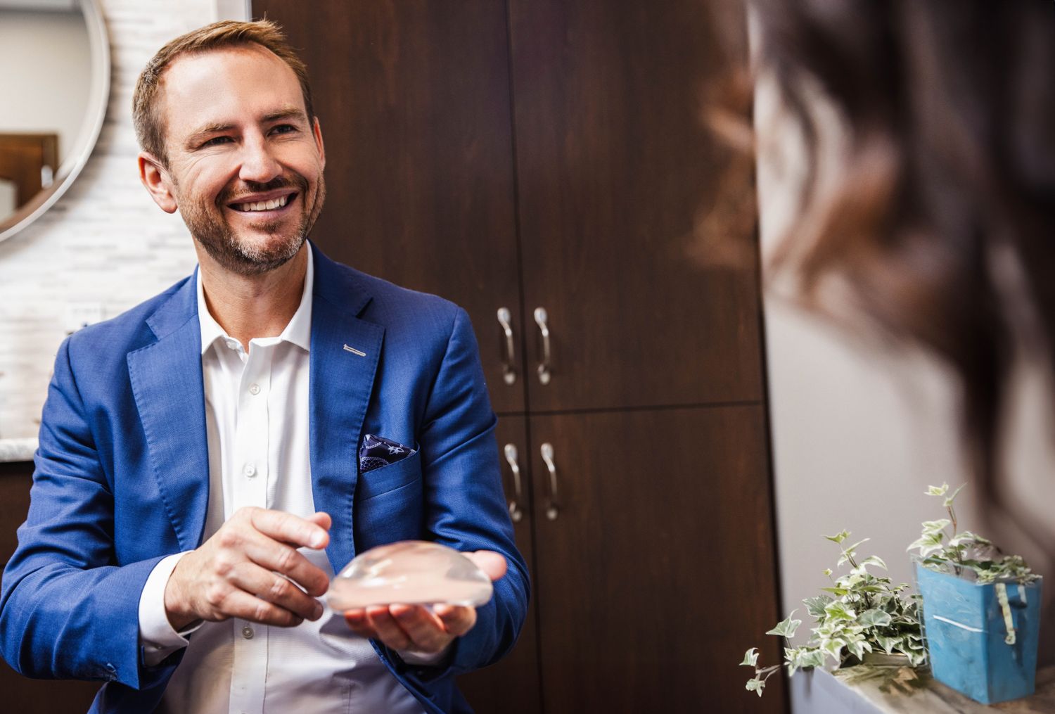 Consultation with doctor holding silicone breast implant.