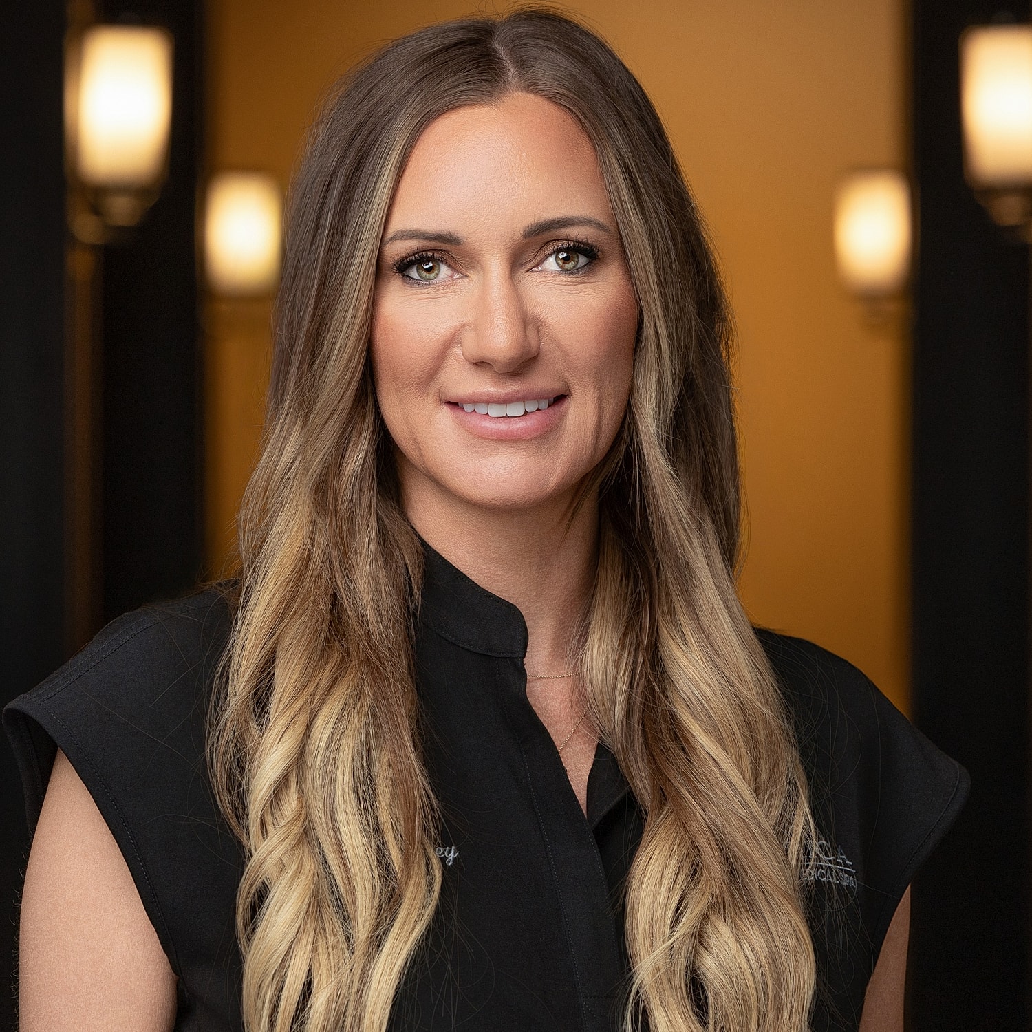 Smiling woman with long hair in black shirt.