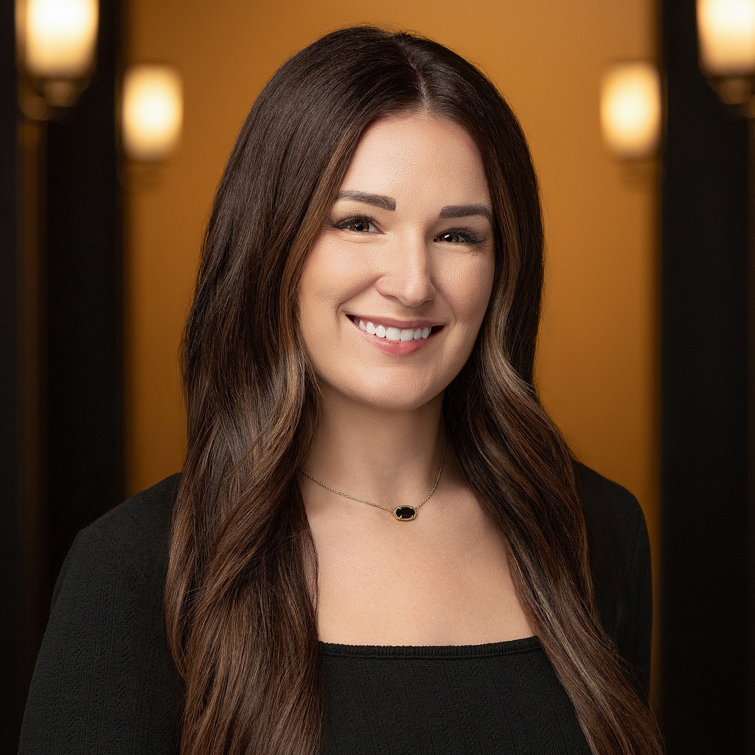 Smiling woman with long, wavy brown hair