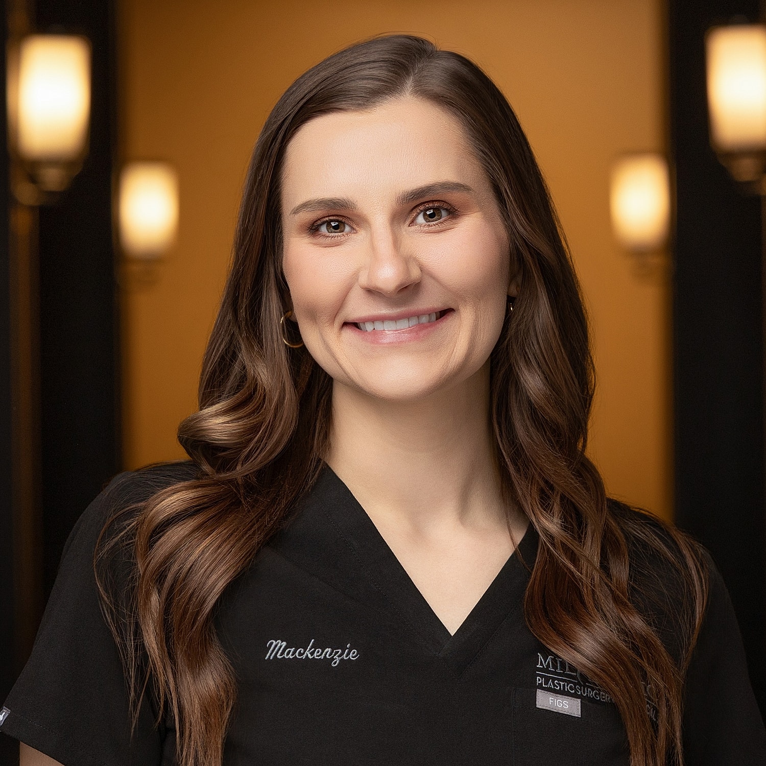 Smiling healthcare professional in surgical attire.