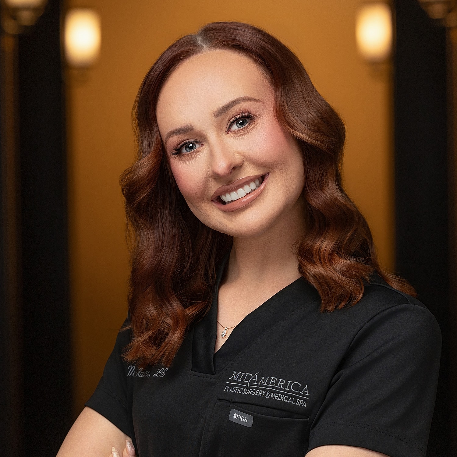 Smiling professional in medical spa attire.