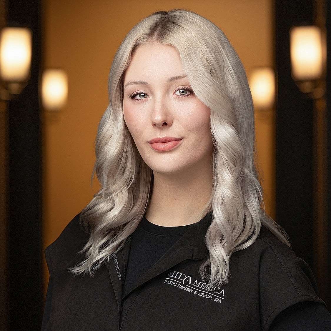 Professional woman in medical attire, smiling confidently.