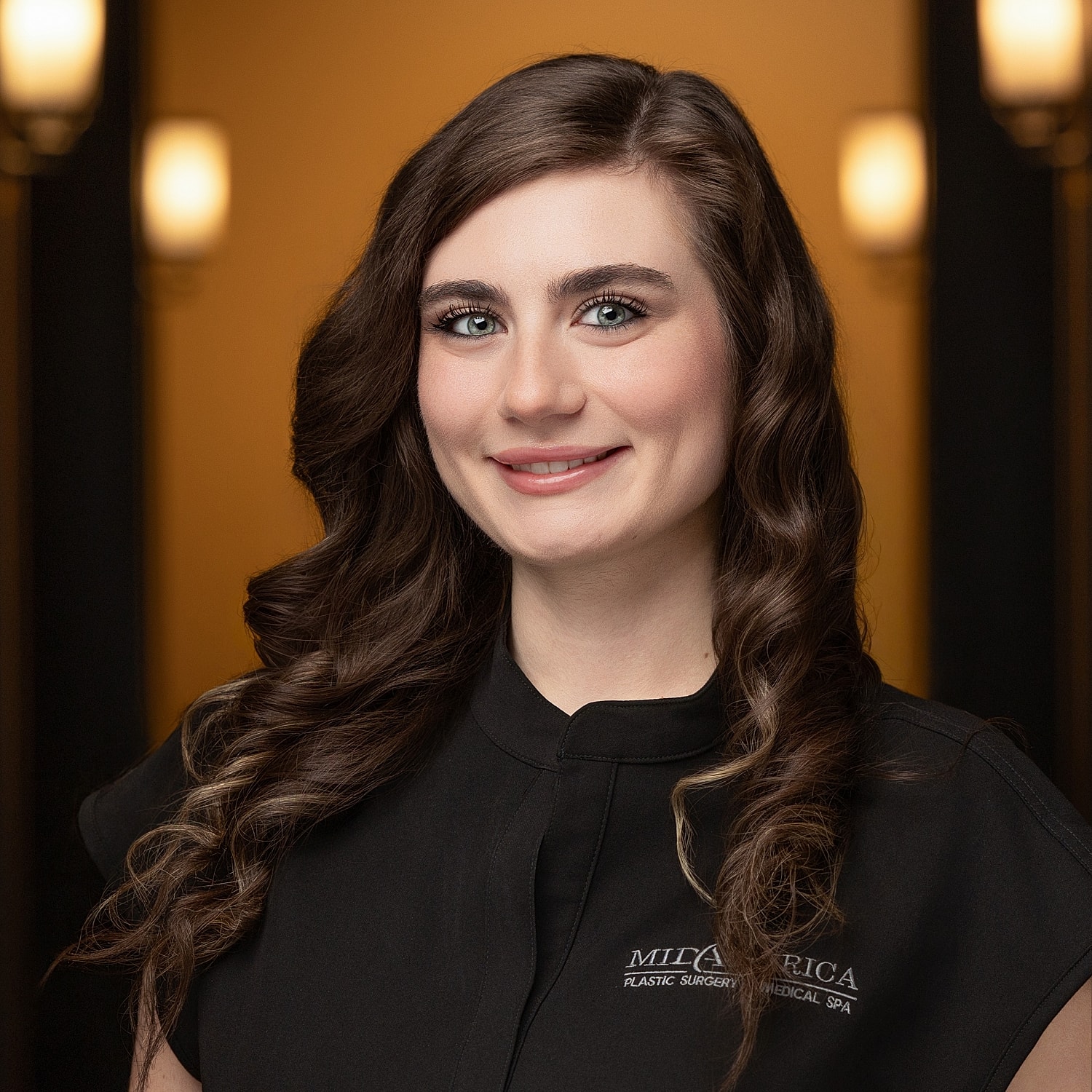 Professional woman with long, wavy hair smiling.