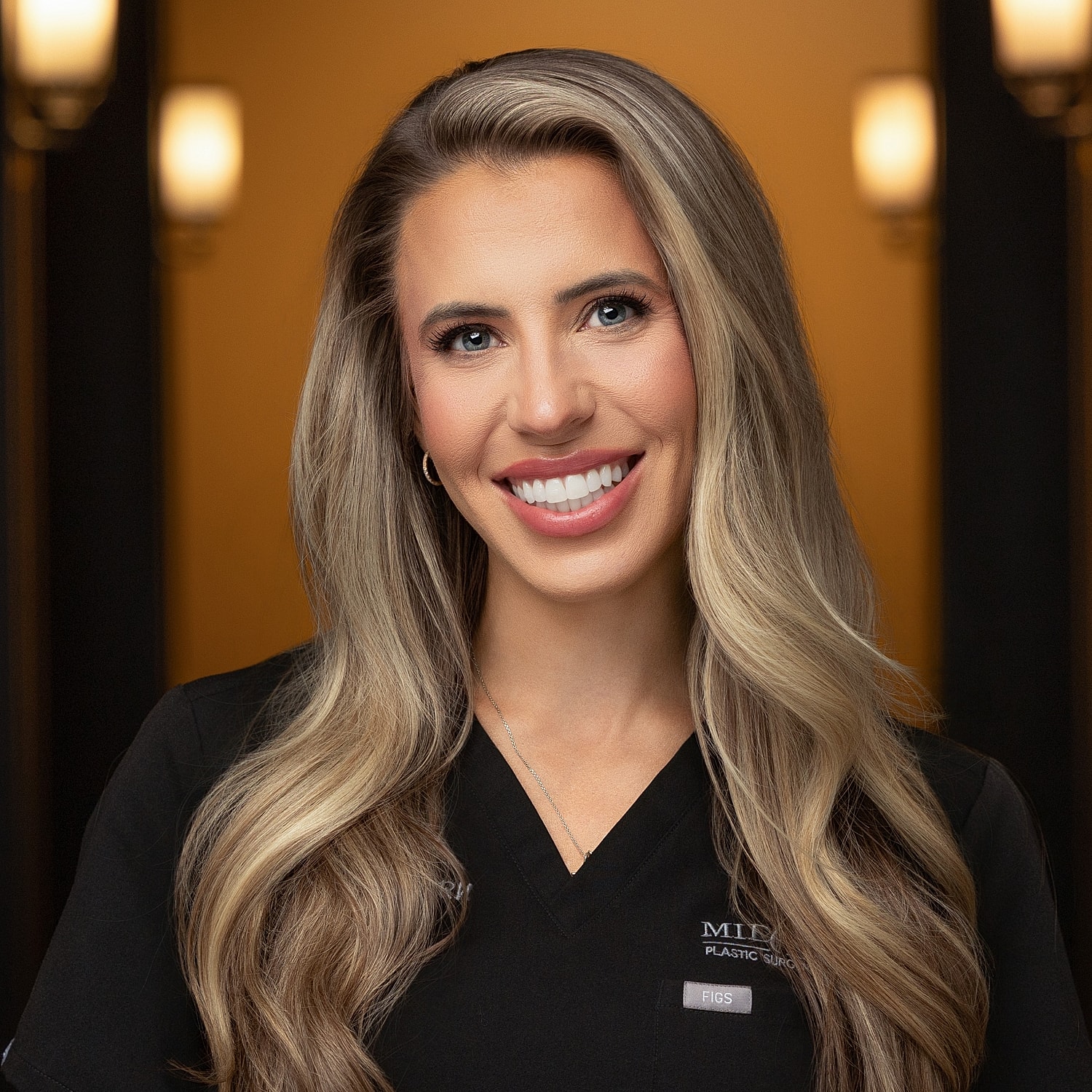 Smiling professional in medical attire, warm background.