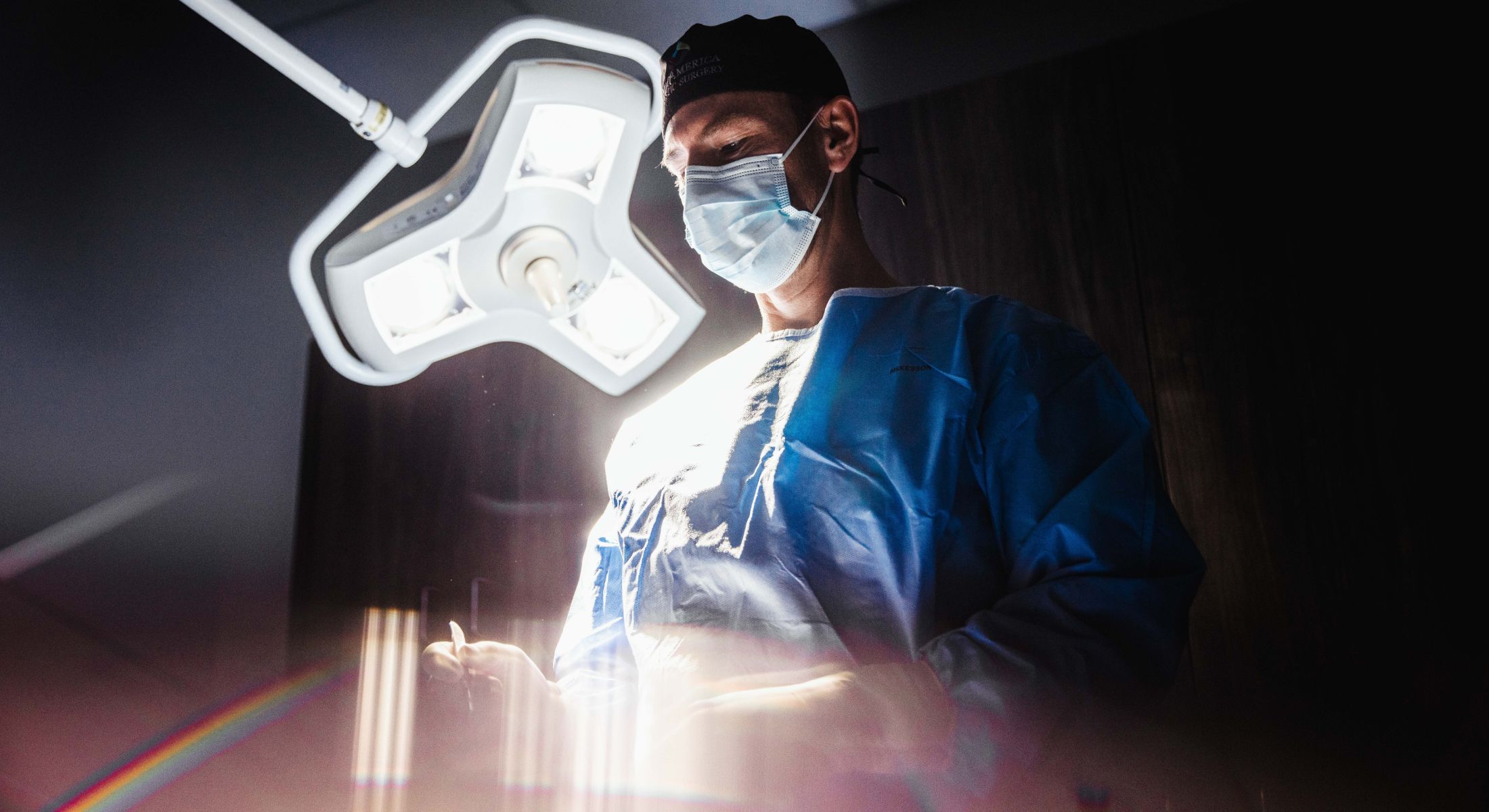 Surgeon preparing for a procedure under bright lights.