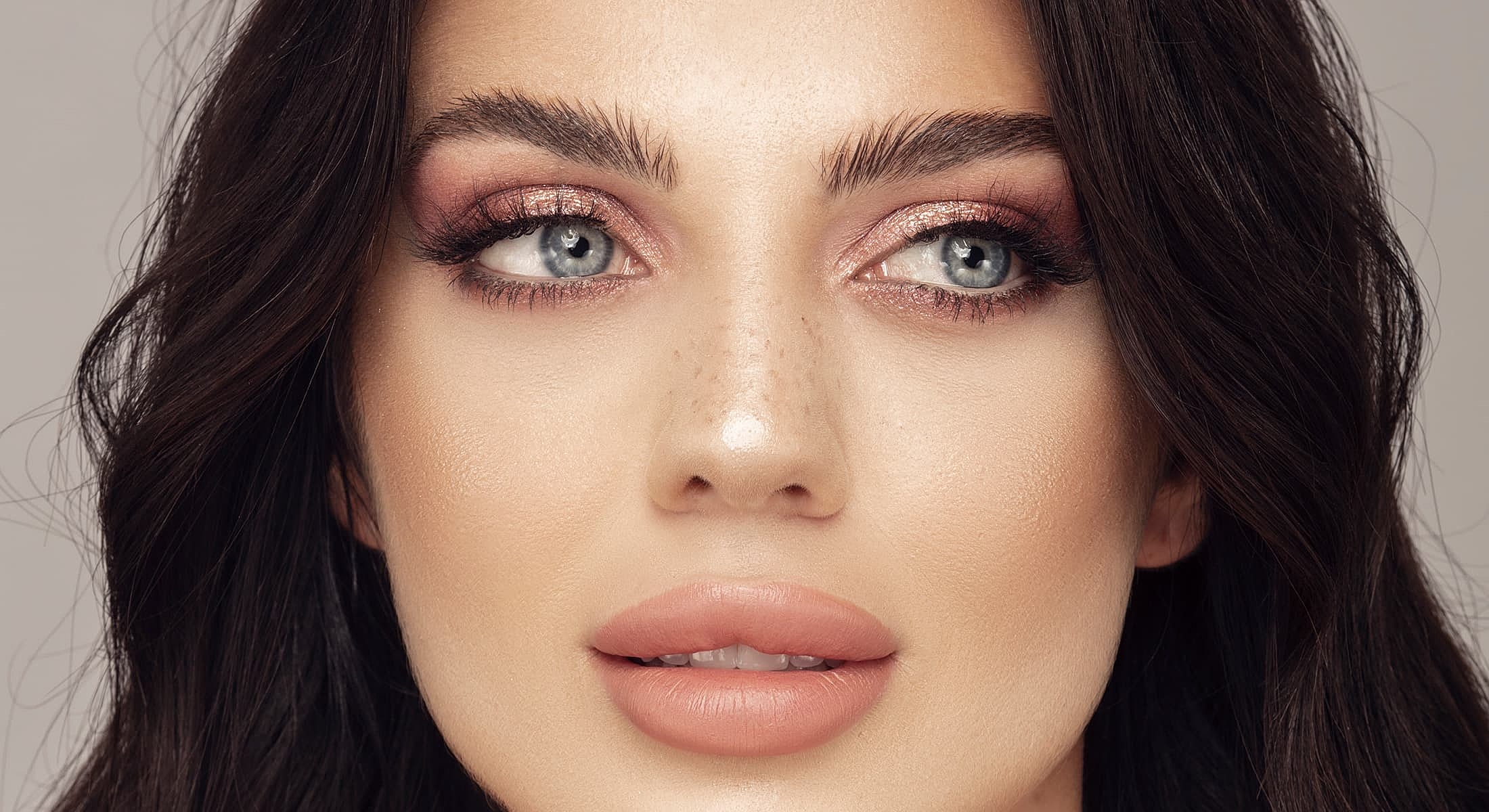 Close-up of woman with makeup and healthy skin.