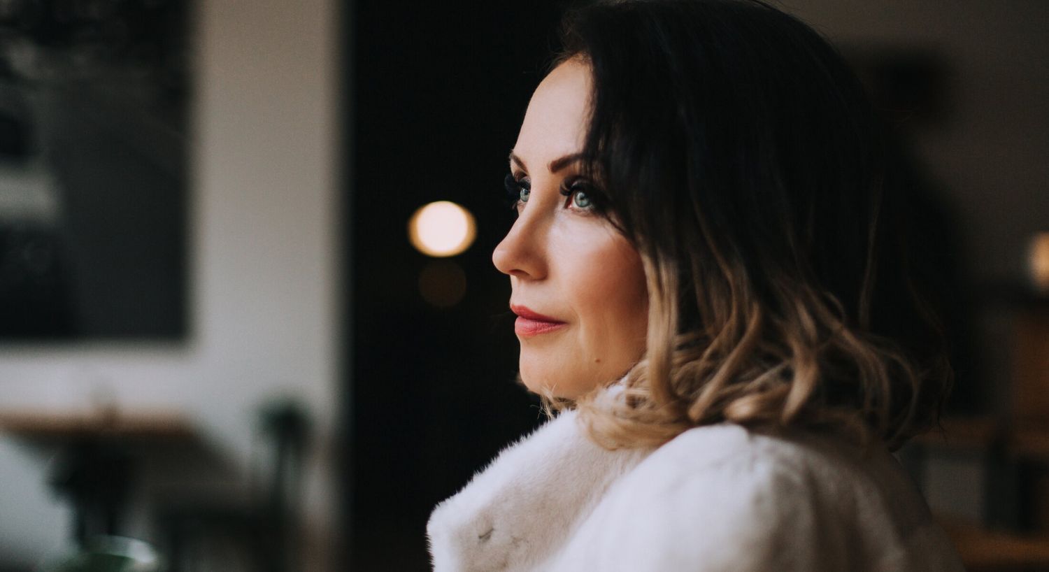 Woman in profile wearing a white coat.