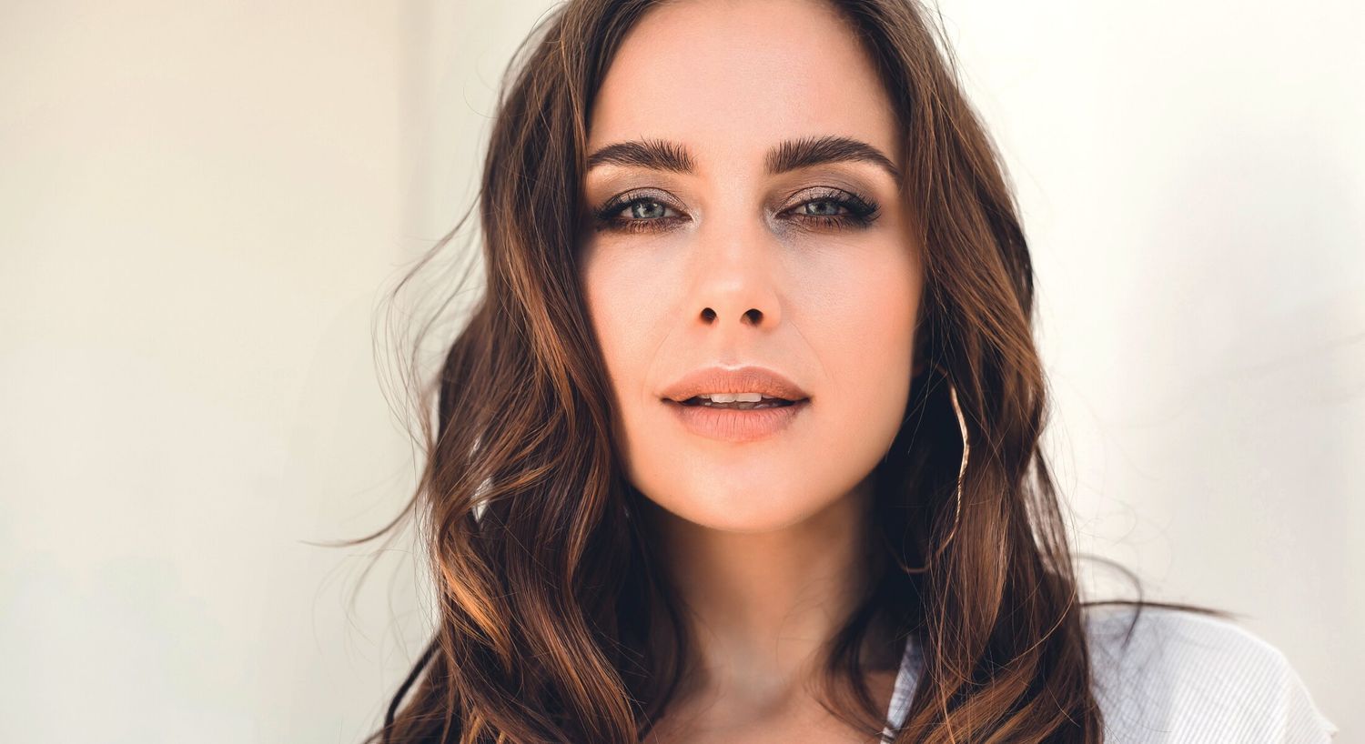 Woman with long brown hair and natural makeup.