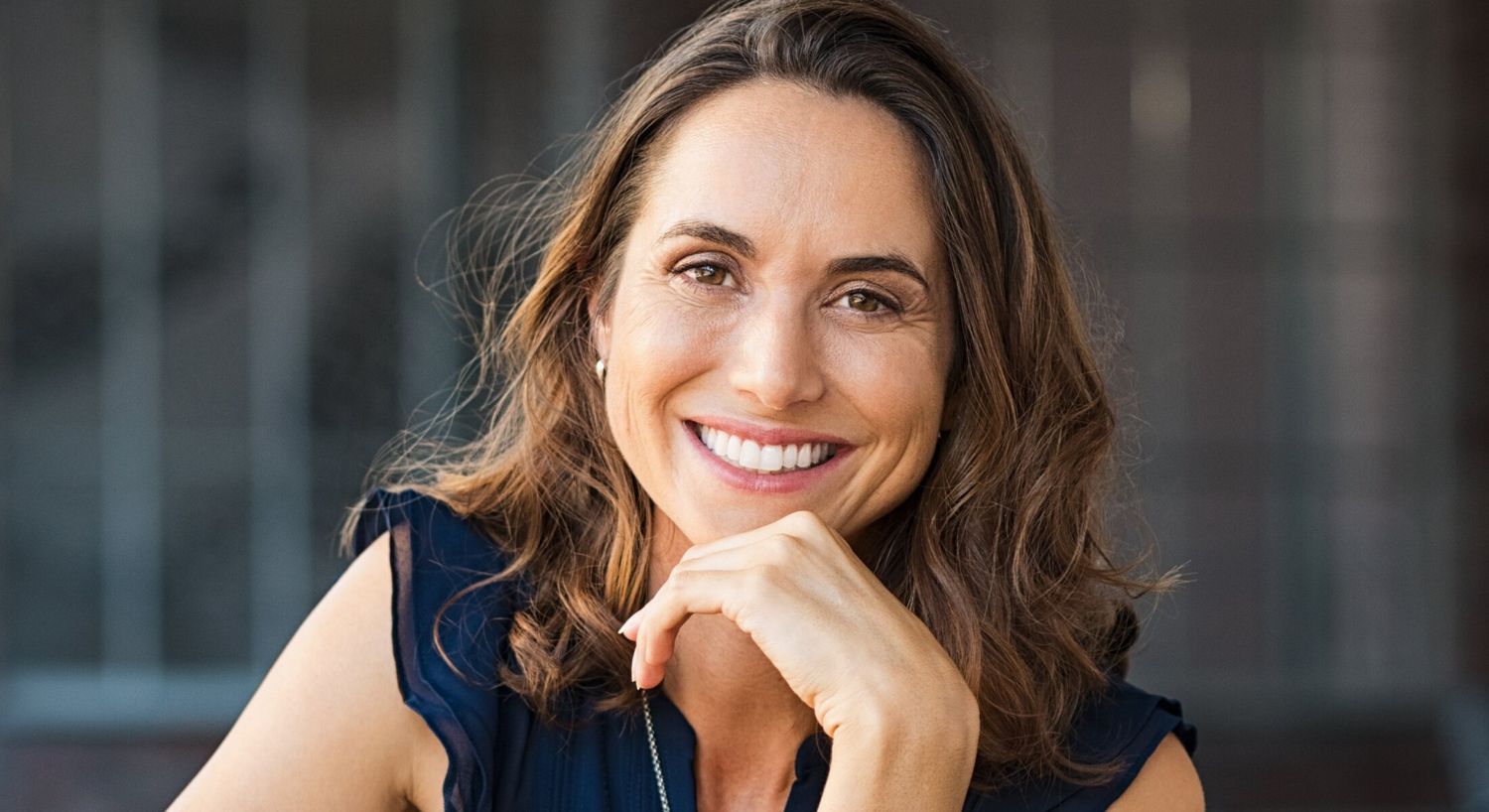 Smiling woman with long, wavy hair.